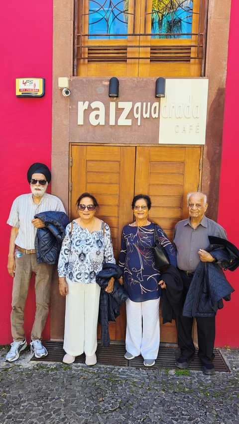       Four people posing in front of wooden doors.
  