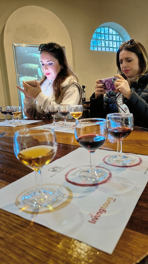       People sitting at a table for a wine tasting event.
  