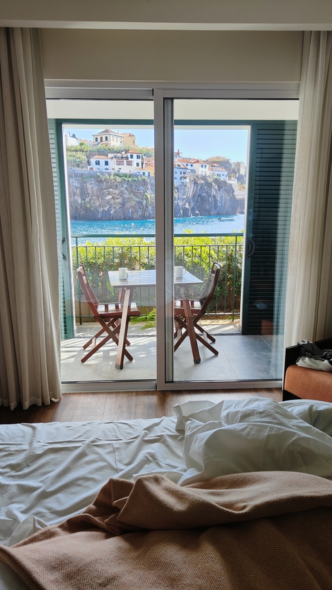       Table and chairs on a balcony overlooking the sea.
  