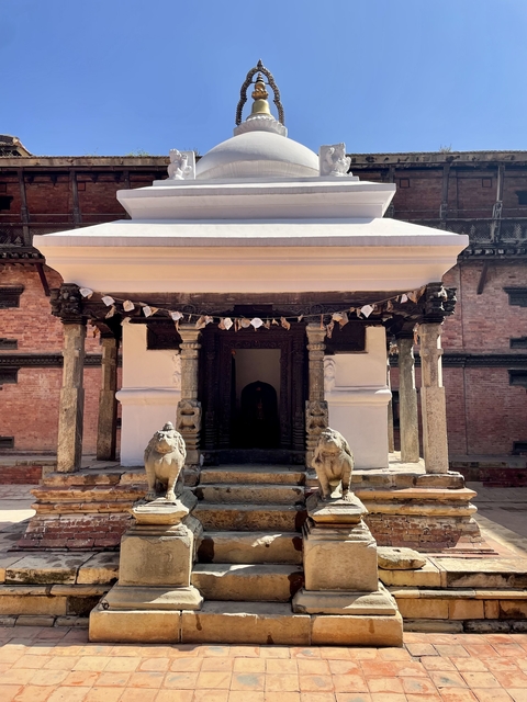       Traditional temple entrance with detailed carvings and lion statues.
  
