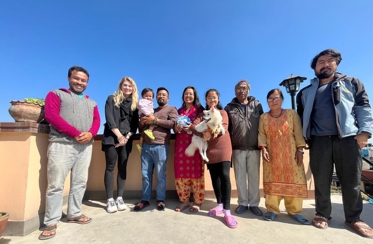       Group of people posing with clear blue sky.
  