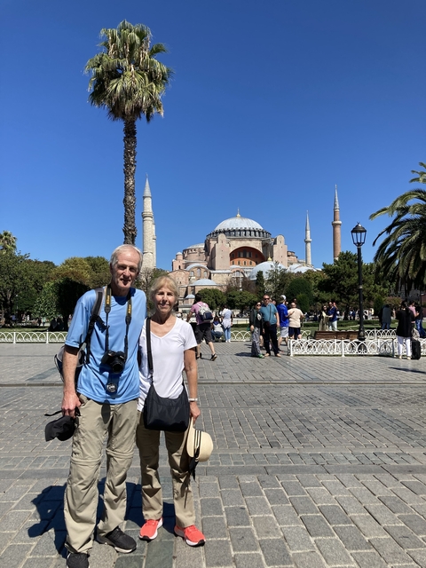 Tourists with a large historical building in the background.