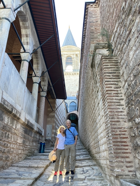 Couple posing in a narrow stone passage.