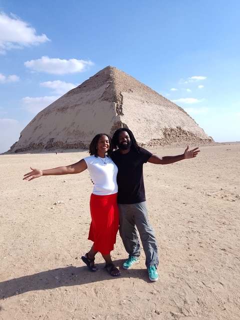 Couple posing with a pyramid in the background.