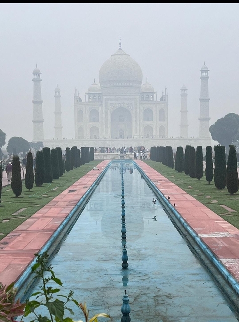 Taj Mahal with reflection in pools and mist.