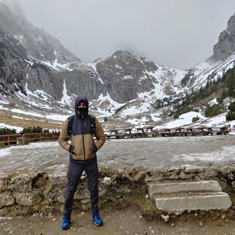 A person standing in a snowy mountain landscape.