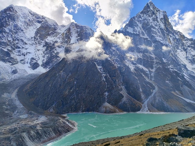       Snow-covered mountains and a turquoise lake.
  