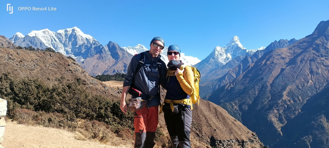       Two hikers posing with mountain peaks in the background.
  