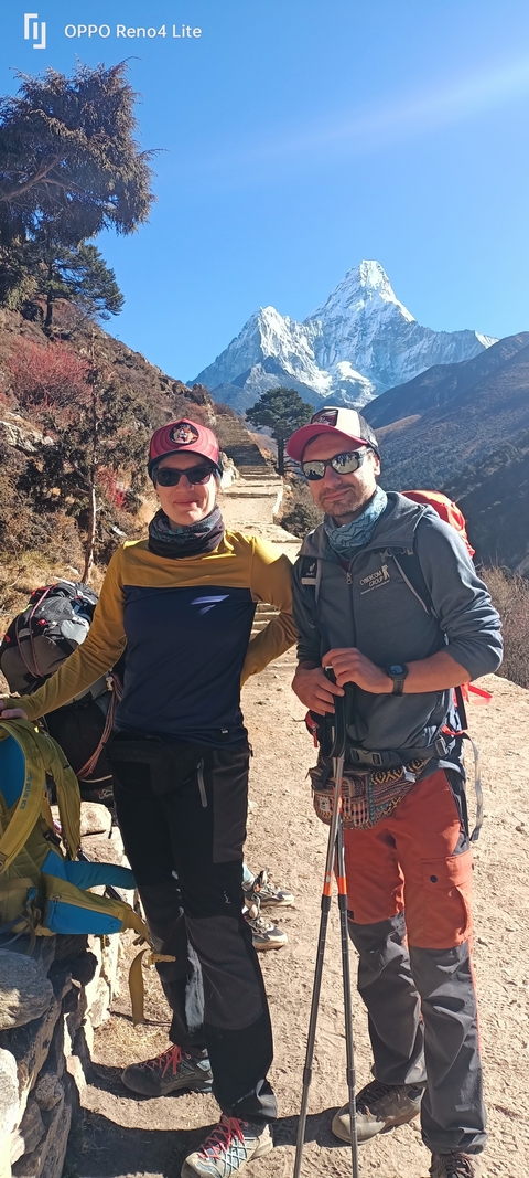       Two people with backpacks posing on a mountain path.
  
