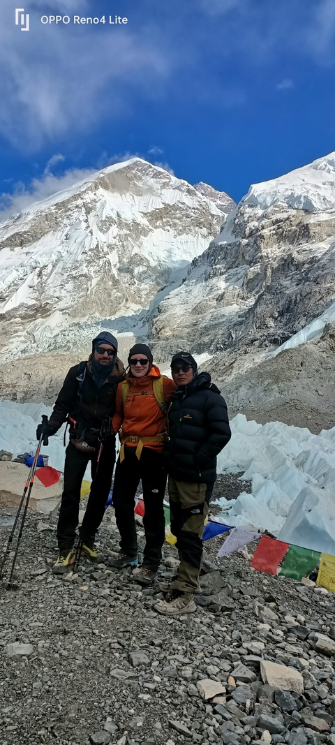       Three people posing in a mountainous snowy landscape.
  