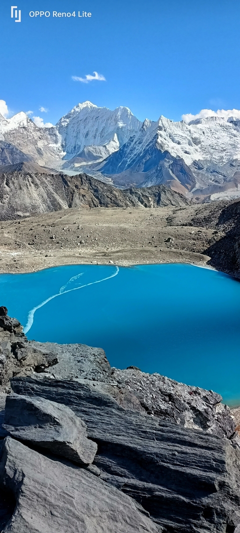       Turquoise lake surrounded by rocky mountains.
  