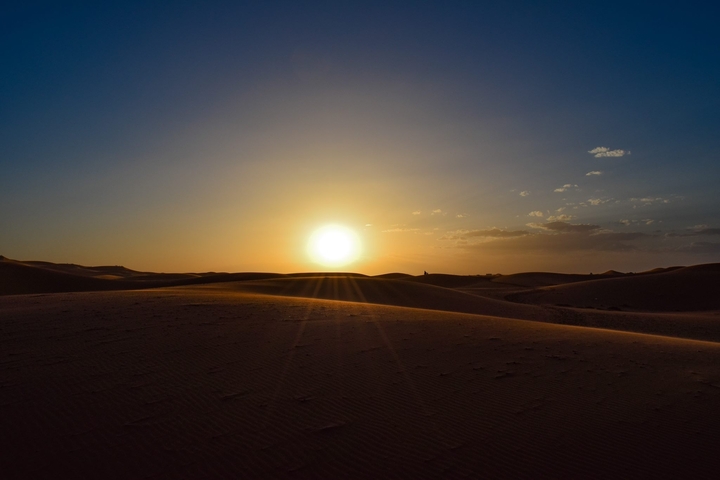       Sunset over sand dunes.
  