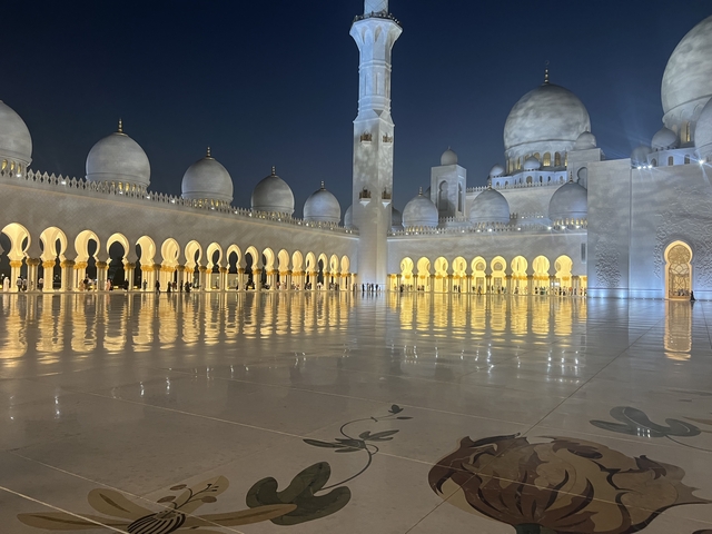       Illuminated mosque courtyard at night.
  