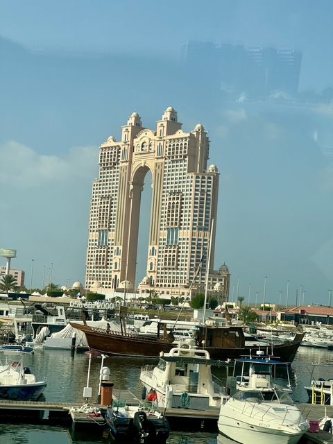       Tall modern arch-shaped building.
  