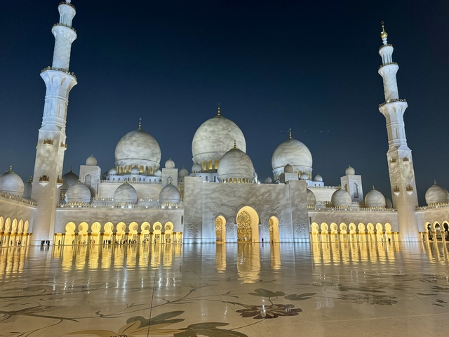       Illuminated mosque with reflection in water.
  