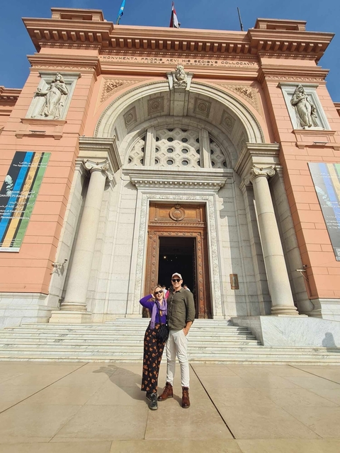 Tourists standing at the entrance of a museum.