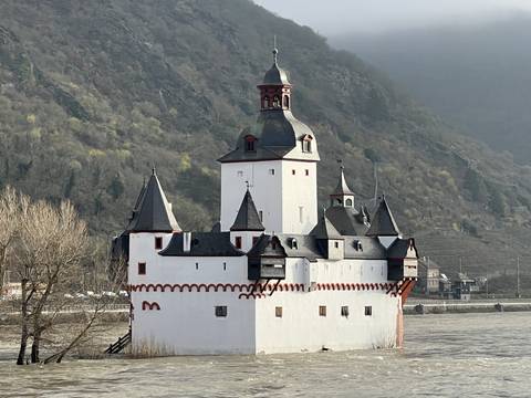 Castle along a river with hills in the background