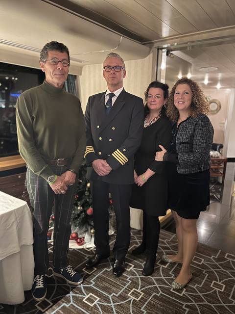 Group posing with a ship captain in formal attire