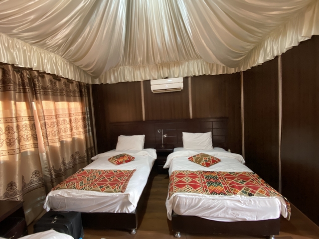 Interior view of a tent accommodation with twin beds.