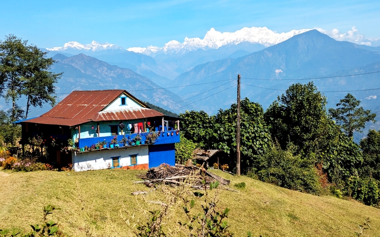 A rustic house with a mountain range in the background.