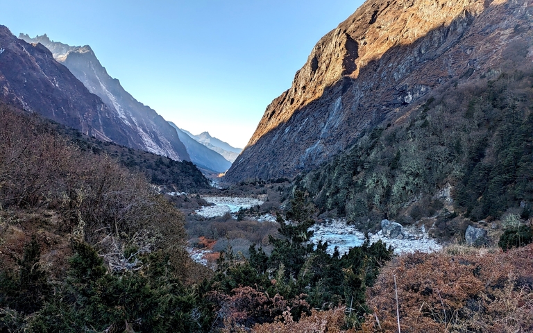       Mountainous landscape with a river and dense foliage.
  