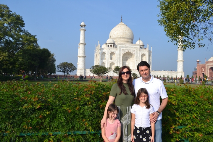 Family posing in front of the Taj Mahal.