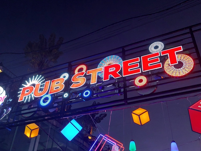 Vibrant sign for Pub Street at night with decorations.