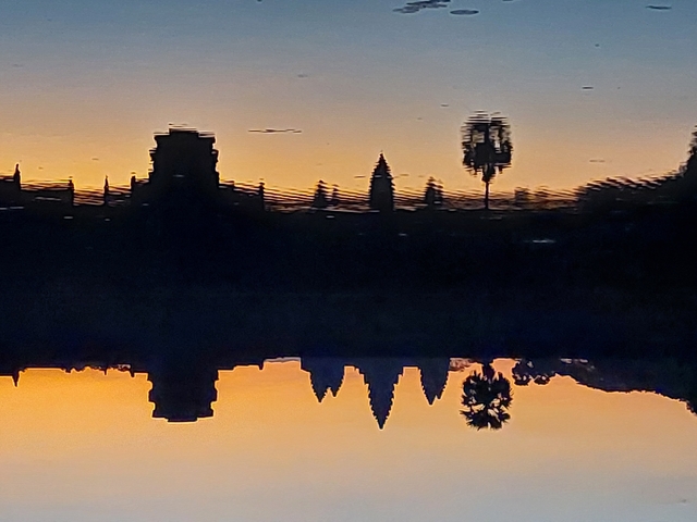       Reflection of temples and palm trees at sunset.
  