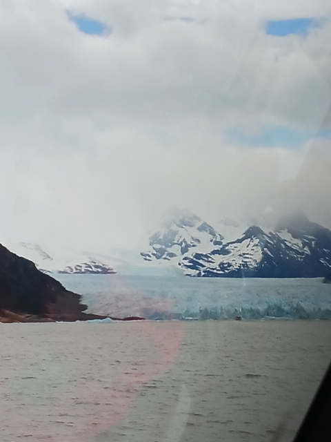      Snow-covered mountains partially obscured by clouds.
  