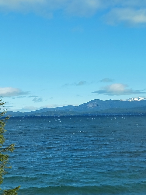       Rustic landscape with mountains and open water.
  