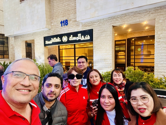 Group of people posing outside a restaurant.