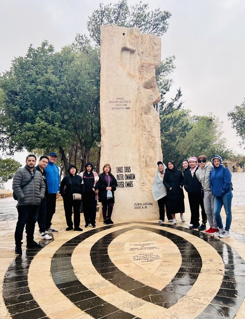 Group photo in front of a large stone inscription.