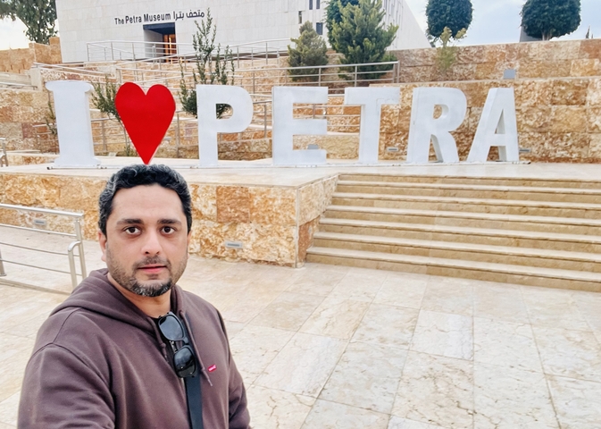       A person posing in front of an 'I love Petra' sign.
  