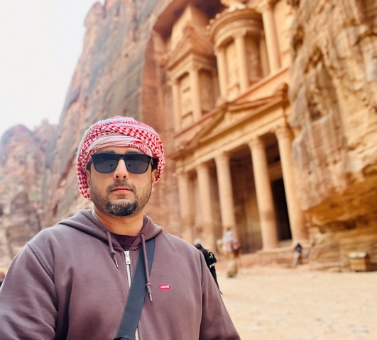       Individual standing in front of the famous rock-cut architecture site.
  