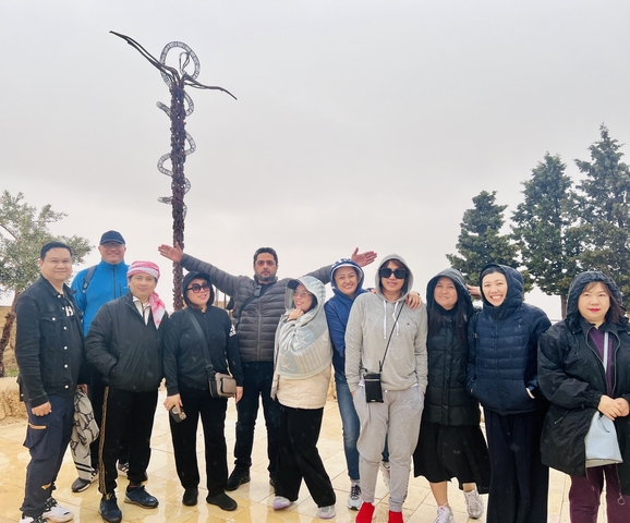       A group posing outdoors in cold weather gear.
  