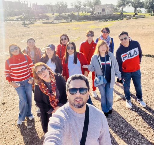       Group of people posing in a rocky desert area.
  