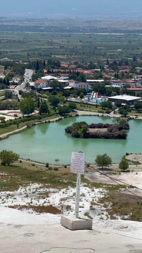       Aerial view of a park and water with buildings.
  