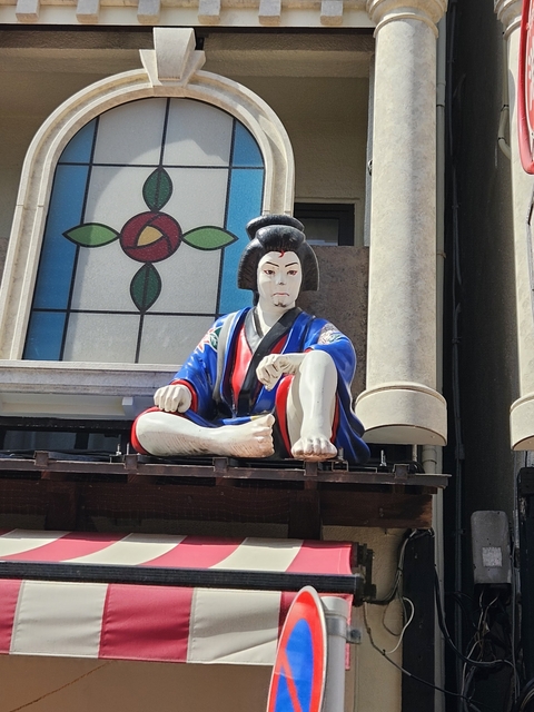Statue of a seated figure in traditional Japanese attire.