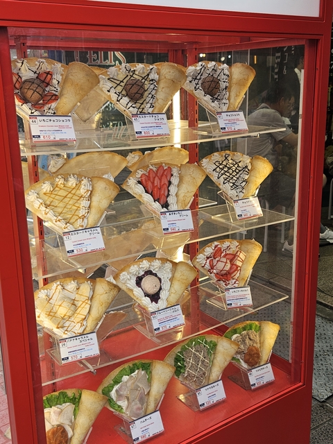       Various crepes displayed in a glass case with price tags.
  