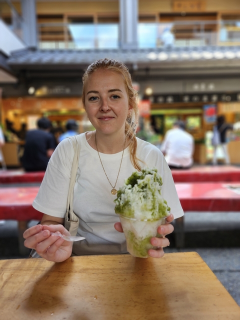 Person holding a dessert bowl with green tea shaved ice.