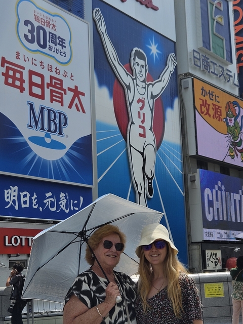 Large billboard with people walking underneath in a city area.
