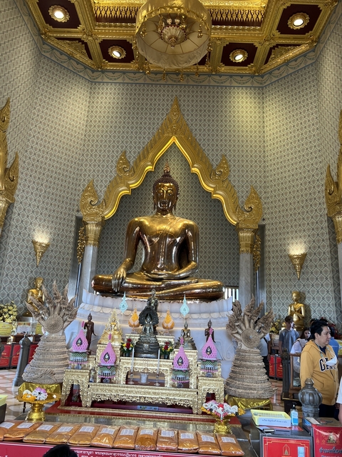 Golden Buddha statue in front of a decorated backdrop.