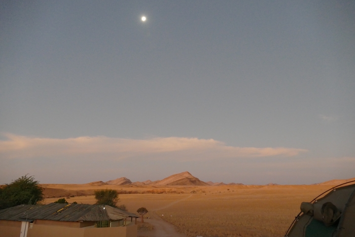 Panoramic view of a desert landscape with a distant mountain.