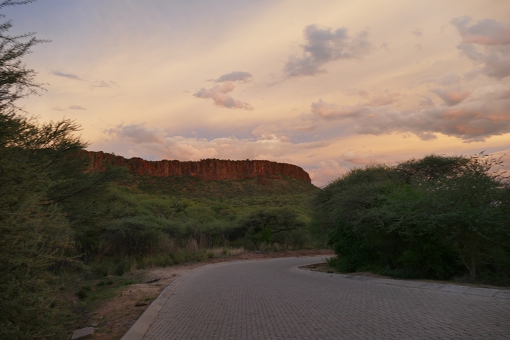 Road leading towards a cliff in the fading light of sunset.