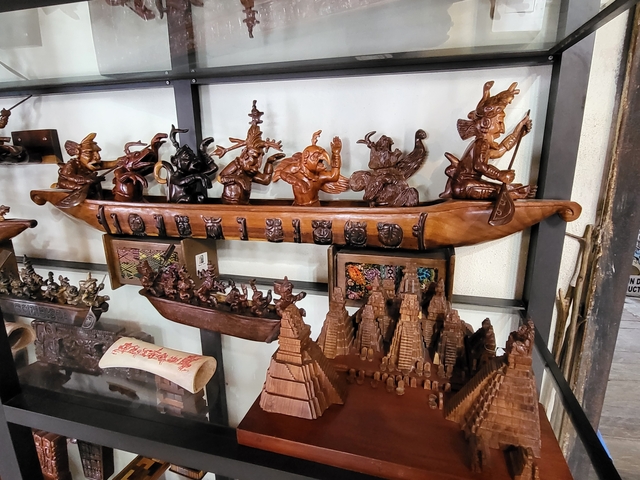 Wooden carvings and sculptures on display inside a shop.
