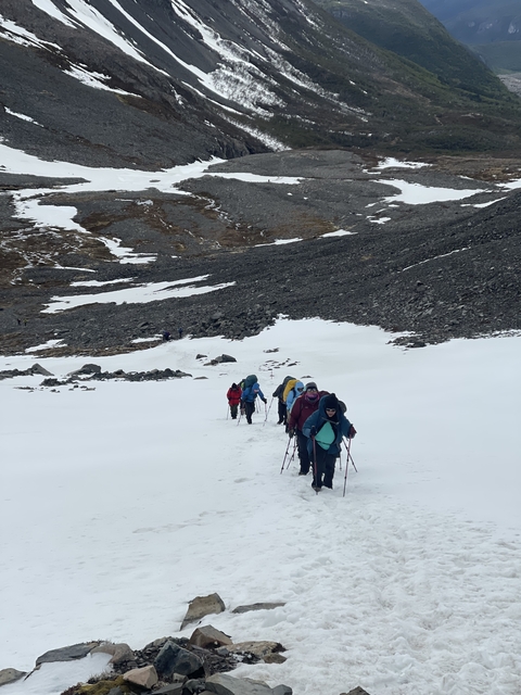 Hikers trekking through snowy landscape.