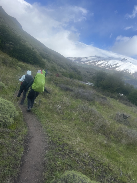       Hikers walking on a path with mountains in the background.
  