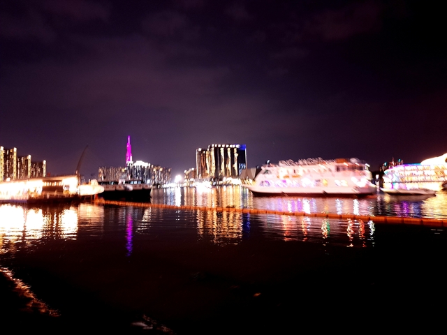       Blurry night view of a city waterfront.
  