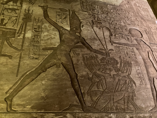       Detailed carvings on an ancient wall depicting historical figures.
  