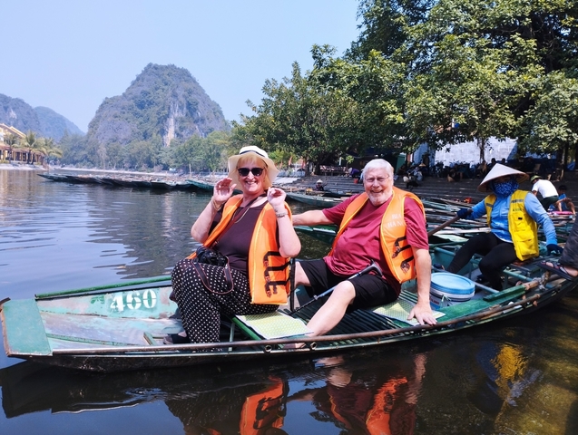 Couple enjoying a boat ride with scenic background.